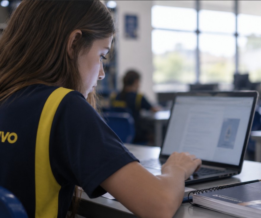 Aluna do Colégio Ipê acessando as videoaulas do Objetivo no notebook